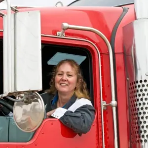 Stock image of a woman in the cab of a big rig